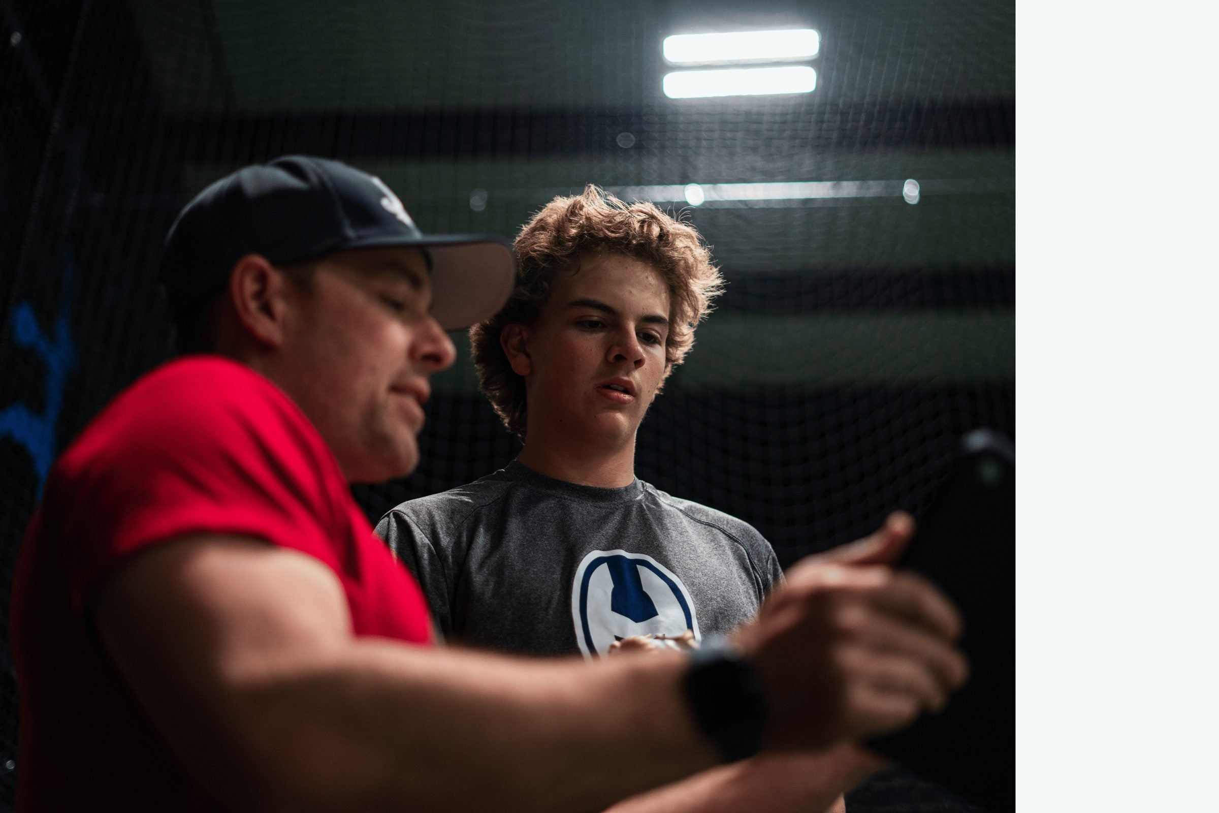 Coach Mike Grady reviewing pitching data with a high school pitcher at the facility